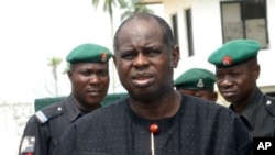 Bayelsa State Governor Diepreye Alamieyeseigha stands outside his house guarded by policemen in Yenagoa, Nigeria, in this photo dated November 27, 2005.