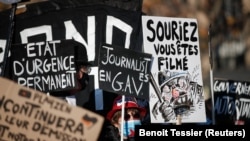 People with banners and posters attend a demonstration against the "Global Security Bill' that rights groups say would make it a crime to circulate an image of a police officer's face and would infringe journalists' freedom in France.