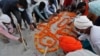 Warga India berdoa usai menguburkan warga korban COVID-19 di tepi Sungai Gangga di kota Prayagraj (16/5).