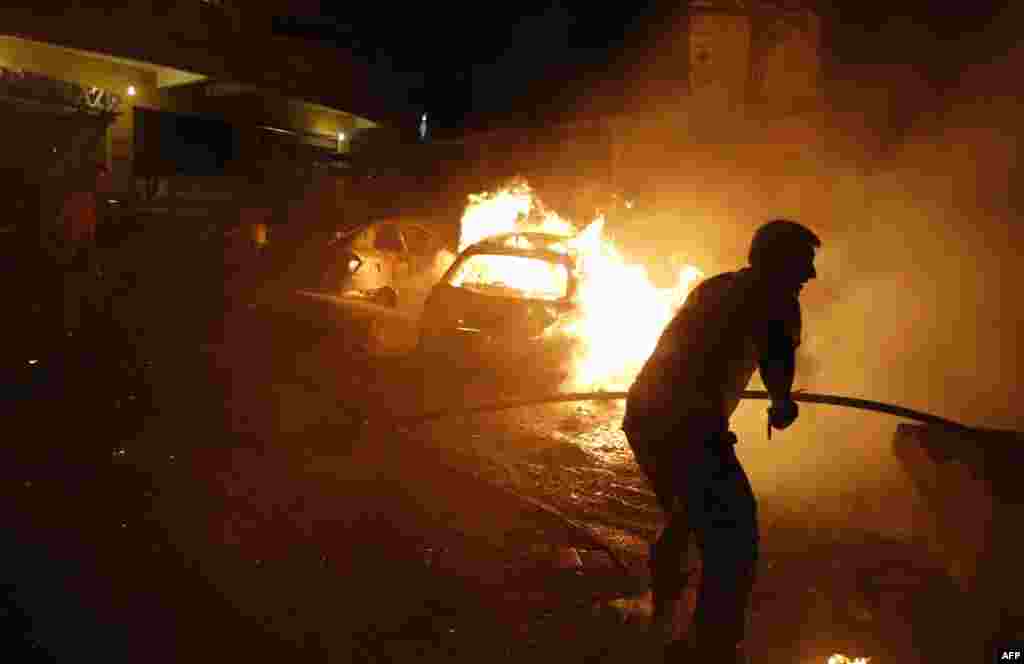 Petugas pemadam kebakaran Lebanon berusaha memadamkan api pasa serangan bom di pinggiran Beirut.