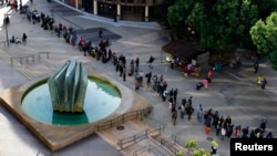 FILE - Homeless families and individuals line up for medical care and other services in San Diego, Calif., Jan. 28, 2015. The homeless of San Diego have been high hardest by an outbreak of hepatitis A.
