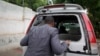 Abdiqadir Dulyar, director for the Somali television station Horn Cable, looks at the smashed window of a car that was carrying journalists working for his station in Mogadishu, May 3, 2016. Unidentified gunmen opened fire on the car last week but no one
was hurt.