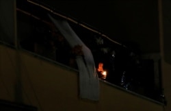 A woman lights a candle on her balcony as faithful across Italy say a prayer for people suffering from coronavirus disease, in Rome, Italy, March 19, 2020.