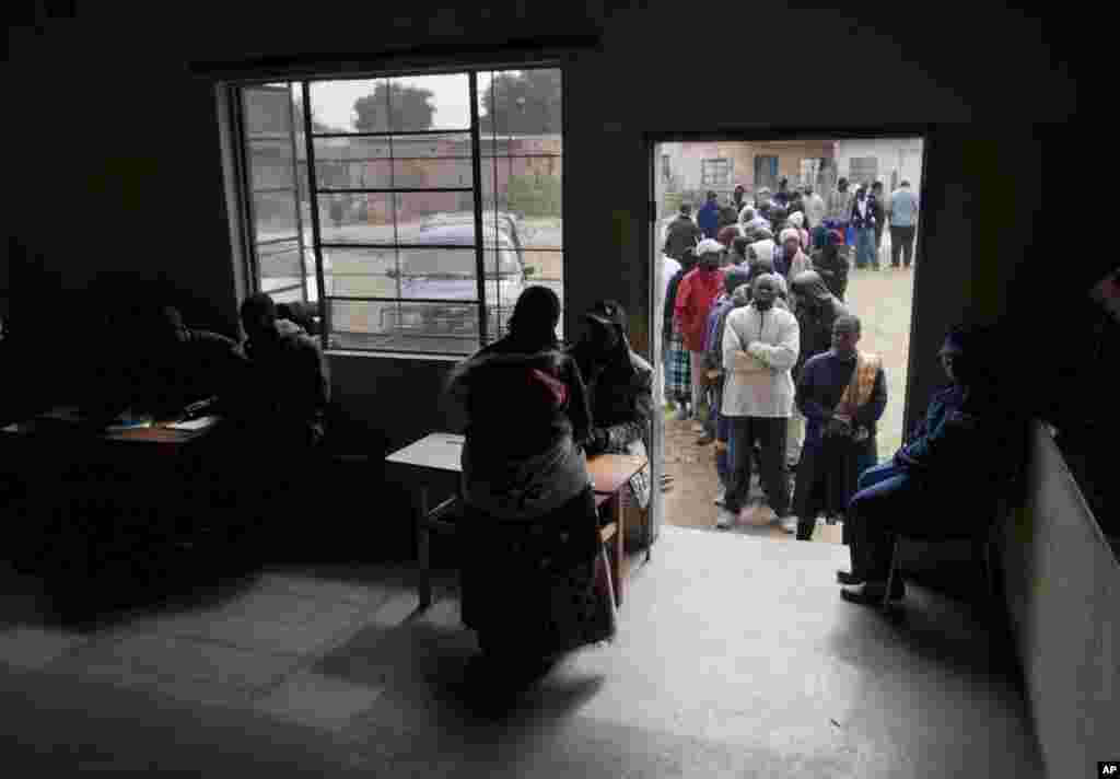 Zimbabweans line up to cast votes in the country's general elections in Morondera, July 31, 2013.