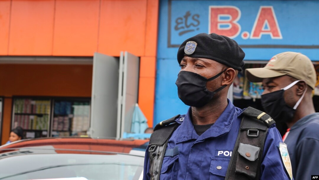 Policier moko azipi zolo na munoko na masque na misala mya kolamusa bato mpo na komibatela na COVID-19, na Kinshasa, RDC, 29 mai 2020.