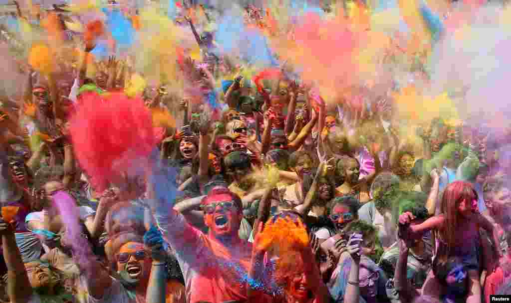 Warga melemparkan bubuk berwarna pada perayaan festival Holi di Santa Coloma de Gramenet, dekat Barcelona, Spanyol.