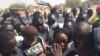 Les étudiants sur les cendres de leur restaurant brûlés par la police entonnant l'hymne national, à N'Djamena, Tchad, le 14 février 2017. (VOA/André Kodmadjingar)