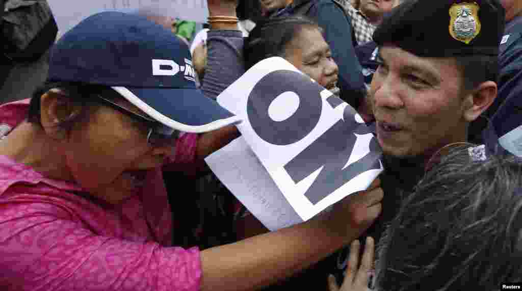 Para demonstran anti-kudeta mendorong polisi dalam sebuah protes di Monumen Kemenangan, Bangkok (27/5). (Reuters/Erik De Castro)