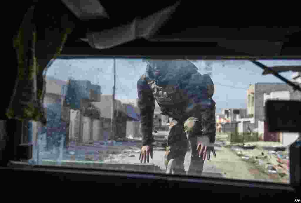 Seorang anggota pasukan khusus Irak mengambil posisi saat bertempur dengan militan ISIS di distrik Samah dan Arbagiah di kota Mosul, Irak utara.