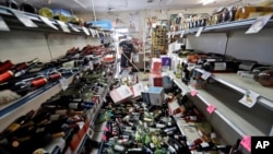Botol-botol anggur berserakan di tengah lorong saat Victor Abdullatif (pemilik toko) membersihkan Eastridge Market, toko keluarganya di Ridgecrest, California, , Sabtu, 6 Juli 2019. 