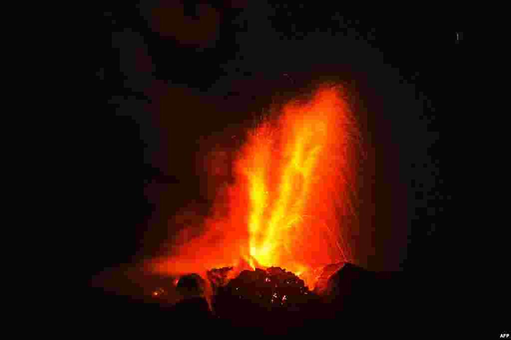Gunung Sinabung memuntahkan abu vulkanik tebal, seperti yang terlihat dari desa Beganding di Karo, Indonesia.