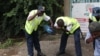 Guards at a nearby building at University Road in central Nairobi wash away tear gas. (M. Yusuf/VOA)