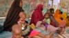 FILE - In this photo taken March 25, 2017, Somali women and their malnourished children attend a health center in Baidoa, Somalia. 