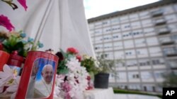 Una vela con la imagen del Papa Francisco frente a las ventanas del Policlínico Universitario Agostino Gemelli en Roma, el domingo 11 de junio de 2023, donde el Papa Francisco se recupera de la cirugía abdominal a la que se sometió el miércoles.