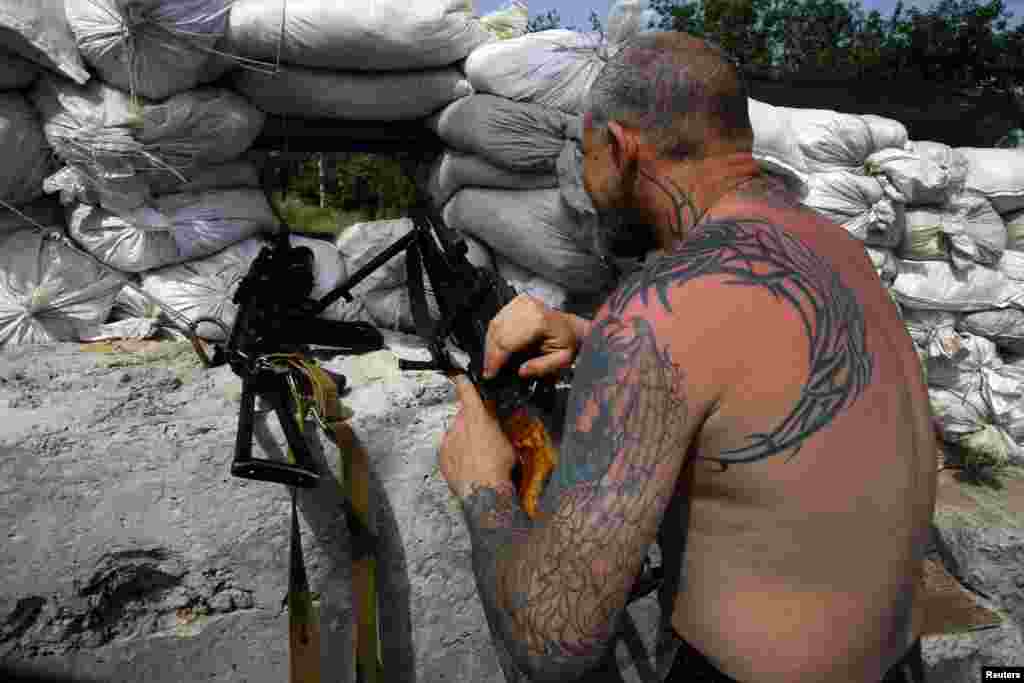 Seorang militan pro-Rusia di posisi pertahanan terdepan dengan senjata mesin di kota Slovyansk (19/5). (Reuters/Yannis Behrakis)