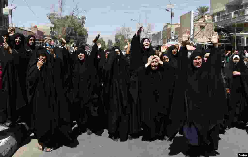 Shi'ite women react during a mass funeral for victims of bomb attacks on a Shi'ite mosque in Baghdad, Sept. 12, 2013.
