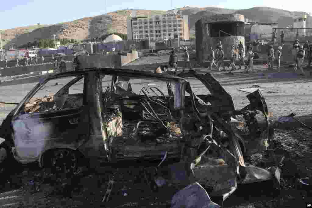 Afghan security personnel investigate a suicide car bombing and a gunfight near the U.S. consulate in Herat, Afghanistan, Sept. 13, 2013.