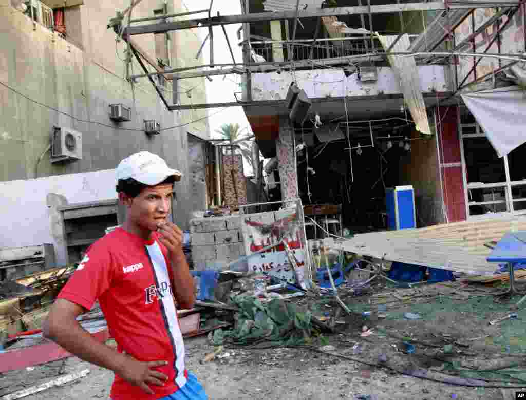 A man inspects the aftermath of a car bomb attack at the Karrada neighborhood of Baghdad, Sept. 4, 2013.