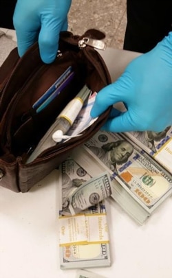 This 2017 U.S. Customs and Border Protection photo shows an agent searching luggage at Washington Dulles International Airport.
