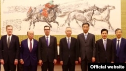 美国贸易代表团成员和中国官员在北京合影，左起：美国贸易代表罗伯特·莱特希泽，美国商务部长威尔伯·罗斯，美国财政部长史蒂文·姆努钦，中国副总理刘鹤，中国财政部长刘昆，中国商务部长钟山，中国人民银行行长易纲。（2018年5月3日或4日，美国驻华大使馆网站图片，照片说明由美国之音撰写）