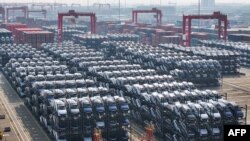 Automjetet elektrike duke pritur për t'u ngarkuar në tragete në portin kinez Suzhou