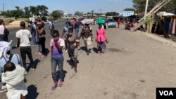 Abanye abantu bayazihambela bengagqokanga ama masks avimba ukumemetheka komkhuhlane weCoronavirus COVID-19. (Columbus Mavhunga/VOA)