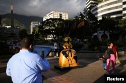 People walk past a sculpture by Venezuelan artist Antonio Azzato as part of the “Meninas Caracas Gallery” street exhibit which pays homage to Spanish artist Diego Velazquez’s “Las Meninas” in Caracas, Venezuela, January 10, 2024. (REUTERS/Gaby Oraa)