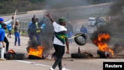 Supporters of former South African President Jacob Zuma block the freeway with burning tyres during a protest in Peacevale, South Africa, July 9, 2021. REUTERS/Rogan Ward