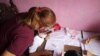 Beatriz Arráiz, docente venezolana con 12 años de experiencia, conversa con una alumna desde la sala de su casa, convertida hoy en un aula escolar, en Caracas. [Foto: VOA/Adriana Núñez Rabascall].