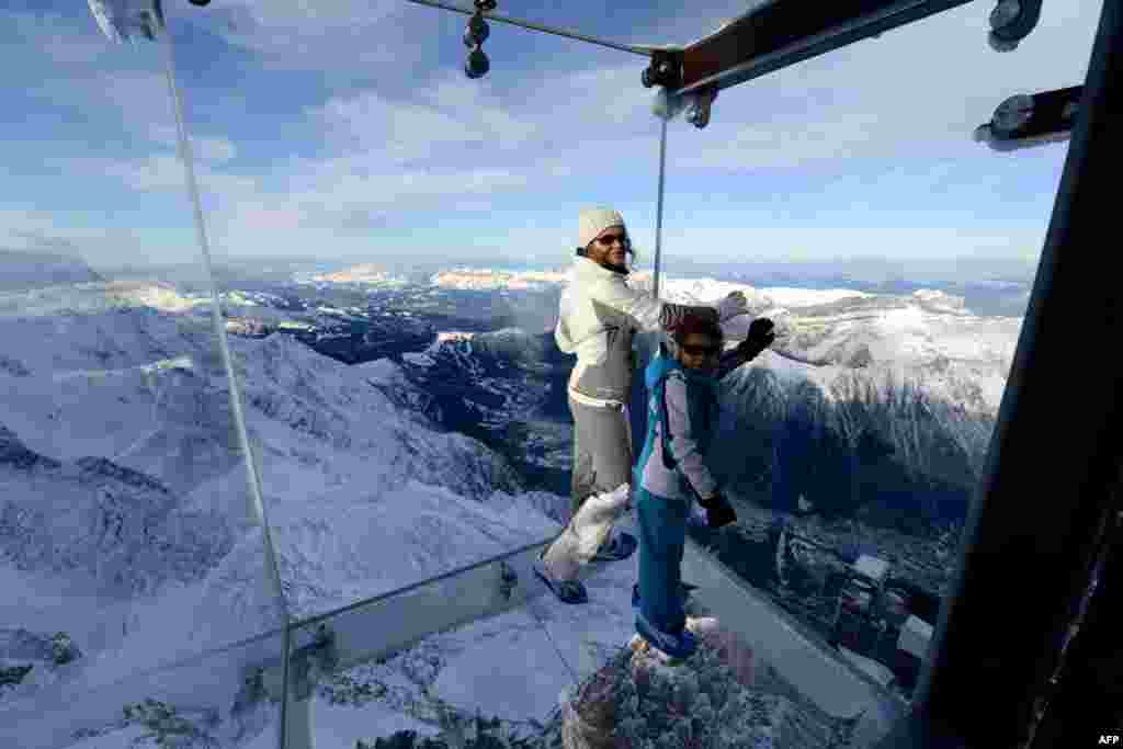 Seorang perempuan dan seorang anak berjalan di atas jembatan kaca (skywalk) sepanjang 1 kilometer, sambil menikmati pemandangan salah satu puncak pegunungan Alpen, yaitu puncak Chamonix, setinggi 3.842-meter di Perancis tenggara.