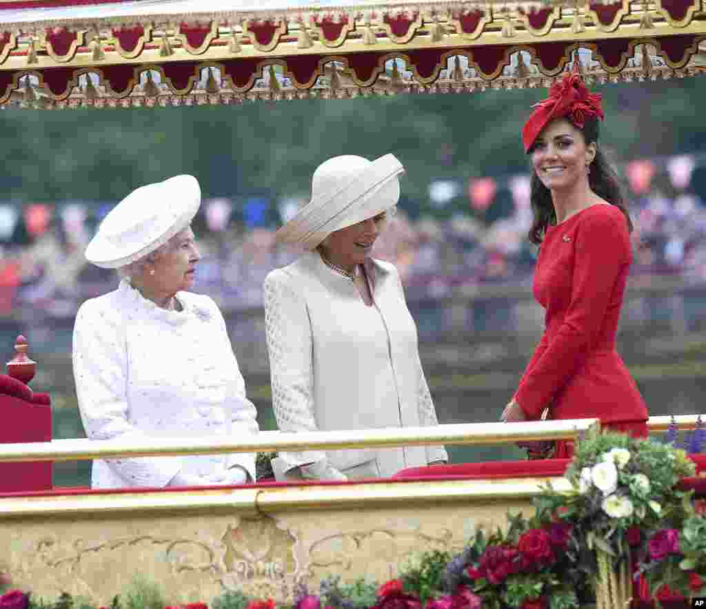 Britain's Kate, Duchess of Cambridge, right, Camilla, Duchess of Cornwall, center, and Queen Elizabeth, look at the proceedings on the royal barge, the principal boat of a flotilla of 1,000 vessels.