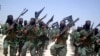 FILE - Al-Shabab fighters march with their weapons during military exercises on the outskirts of Mogadishu, Somalia, Feb. 17, 2011. 