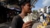Un joven muestra sus billetes de un dólar en un mercado en Caracas, el 11 de junio de 2021. 