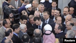 Syria's President Bashar al-Assad (C) chats with people after prayers for Eid al-Adha at al-Afram Mosque, Damascus, Syria, October 26, 2012.