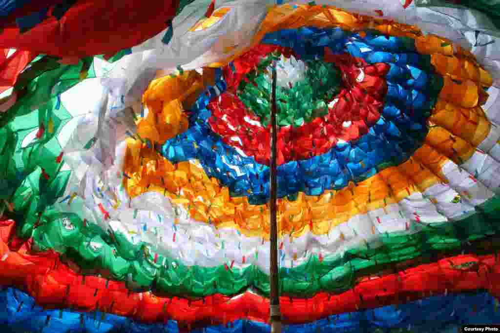 An estimated 1,000 Tibetan prayer flags flutter in the wind as they form the shape of a giant pagoda at Khadiravana Center, Hua Hin, Thailand's only institution dedicated to the teaching and learning of Tibetan Buddhism and the art and culture of Tibet and the Himalayas, July 6, 2014. (Photo taken by Matthew Richards/VOA reader)
