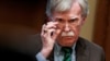 FILE - National Security Adviser John Bolton adjusts his glasses during a meeting in the Oval Office at the White House in Washington, April 2, 2019.