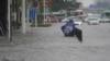 A resident stands on a flooded road in Zhengzhou, Henan province, China July 20, 2021.