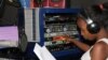 Florence Mwale, host of Business Today show at Capita Radio, presses the profanity-delay button to block obscene and offensive language. (L. Masina for VOA)
