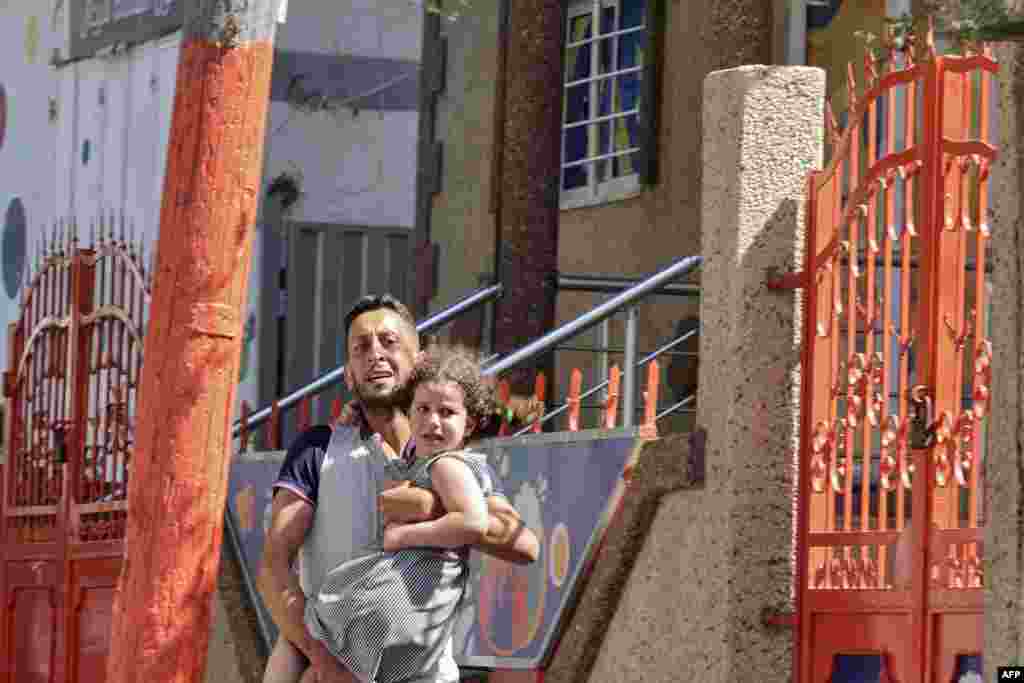 A Palestinian man carries his daughter after evacuating his home during an Israeli air strike in Gaza City.&nbsp;&nbsp;Israel bombarded Islamic Jihad positions in the Gaza Strip for a third day as violence escalated, with 31 Palestinians killed and militants firing their first rockets at Jerusalem.