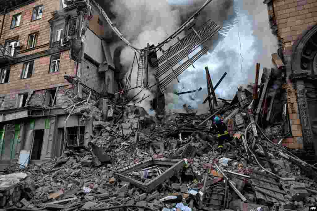 A Ukrainian firefighter puts out a fire after a strike in Zaporizhzhia amid the Russian invasion of Ukraine.