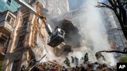 Wafanyakazi wa zima moto wakijaribu kuzima moto baada ya shambulio la ndege isiyo na rubani kwenye makazi mjini Kyiv, Oktoba 17, 2022. Picha ya AP