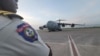 Yon polisye Ayisyen nan ayewopo Potoprens la nan moman avyon Aviyasyon Etazini ak Kanada rive pou livre asistans pou Polis Nasyonal Ayiti. (Foto: @USEmbassyHaiti Twitter)
