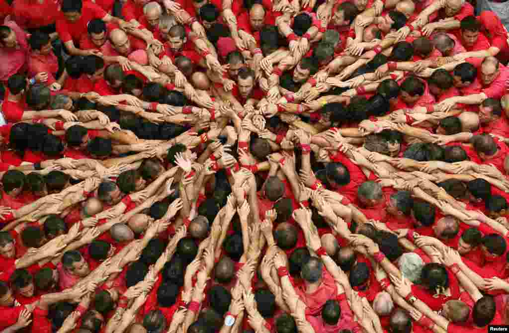 Warga di kota Barcelona merayakan festival 'Sant Joan' (Yohanes) di Plaza del Blat dengan membentuk 'menara manusia'.