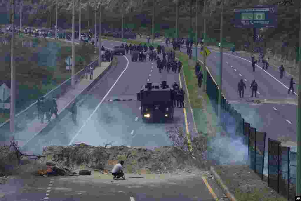 Police advance on people protesting the rise in gas prices and the policies of Ecuador's President Guillermo Lasso, on the second day of a general nation-wide strike, in Quito, Oct. 27, 2021.