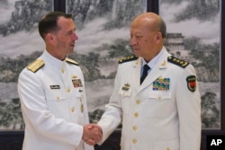 美国海军作战部长理查森和中国海军司令吴胜利在北京的中国海军总部握手（2016年7月18日）