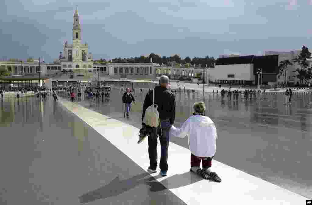 Seorang peziarah Katolik berjalan dengan lututnya di tempat kudus Fatima di Fatima, Portugal.