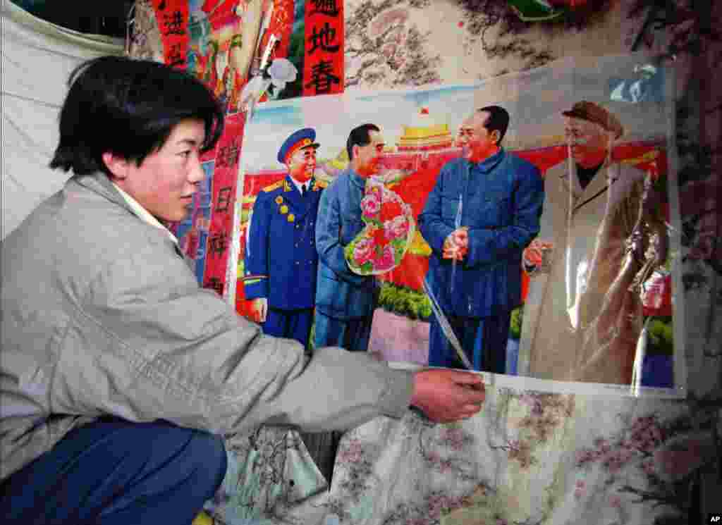 天安门广场上有小贩把中共领袖像作为年画出售。画上左起:朱德,周恩来,毛泽东和刘少奇(1997年1月27日)