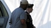 Army Pfc. Bradley Manning, right, is escorted into a courthouse in Fort Meade, Maryland, before a court martial hearing, July 18, 2013.