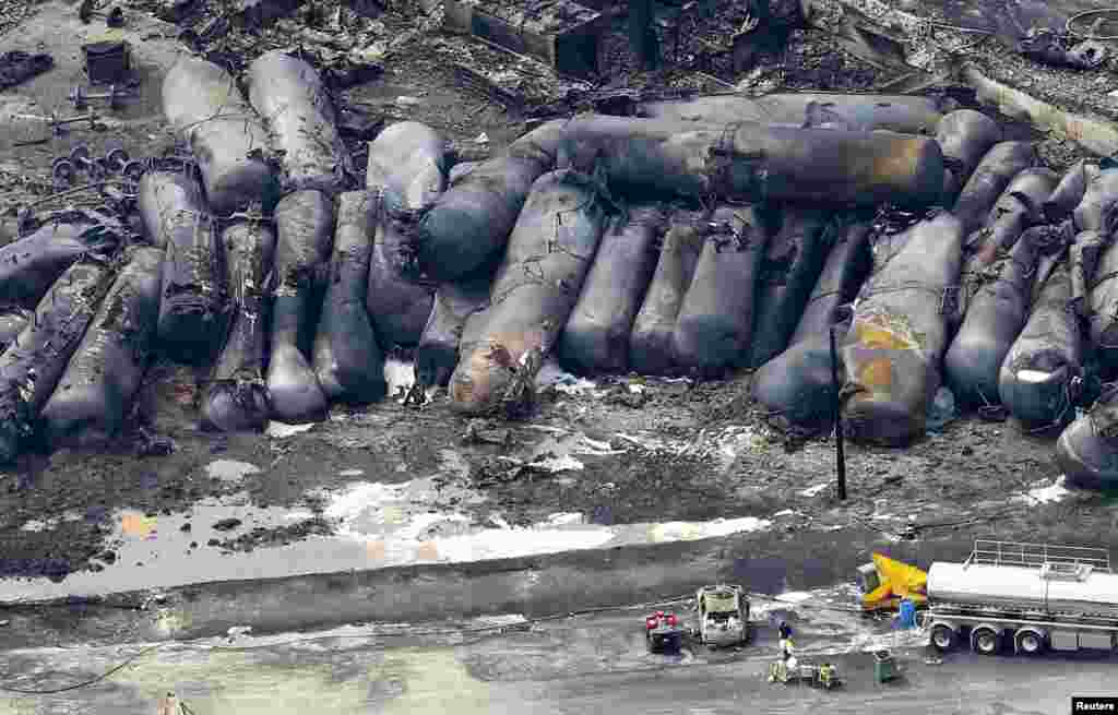 Seorang petugas pemadam kebakaran berdiri di dekat sisa-sisa reruntuhan kereta tangki minyak di Lac-Megantic, Quebec, Kanada.
