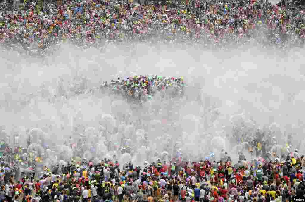 Para pengunjung berpartisipasi dalam festival perayaan tahun baru etnis minoritas Dai di kota Xishuang Banna, provinsi Yunnan, China.